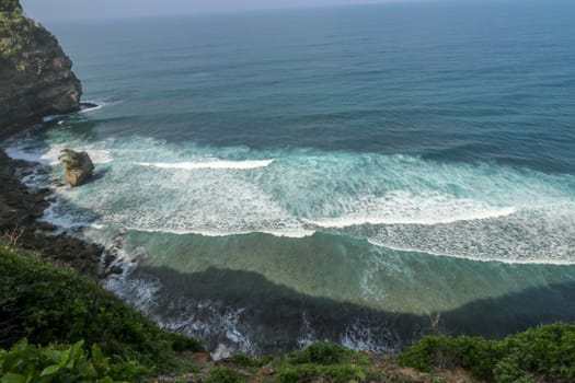 Pura Luhur Uluwatu Temple is a Balinese Hindu sea temple in Bali, Indonesia. It�s renowned for its magnificent location, perched on top of a cliff. Amazing landscape - cliff with blue sky and sea.