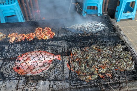 Serving food prepared for barbecue in excellent warung at the fish market on tropical Bali island in Jimbaran. Fresh, healthy and delicious seafood. Fish, shrimp, crawfish, octopus, squid, clams.