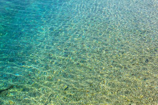 Beautiful background of crystal clear transparent sea water at sunny day