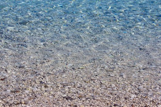 Beautiful background of crystal clear transparent sea water at sunny day