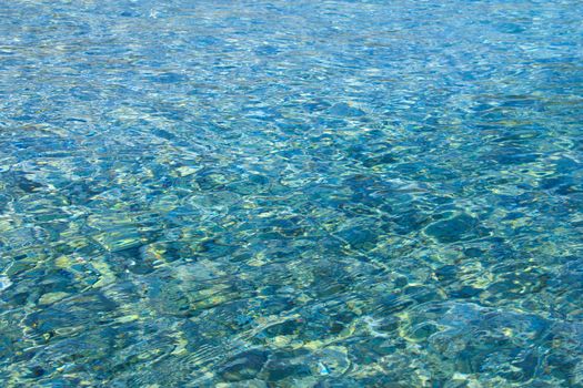 Beautiful background of crystal clear transparent sea water at sunny day