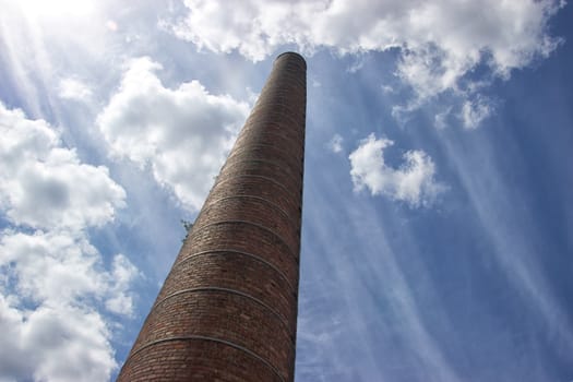 industrial tower on a sunny day, clouds and blue sky, abandoned place