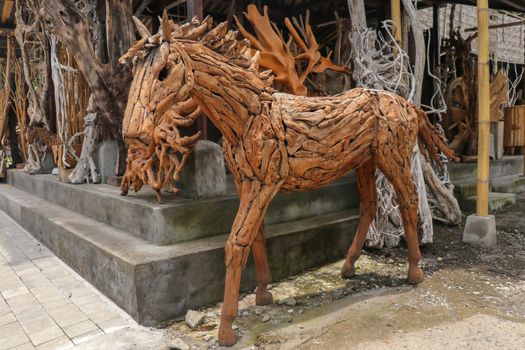 Wooden statue of a horse. Art and work of Balinese artists. Wooden art. Horse made of pieces of old wood. Big horse head art statue from wooden pieces. Ubud, Bali, Indonesia. March 2020.