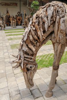 Wooden statue of a horse. Art and work of Balinese artists. Wooden art. Horse made of pieces of old wood. Big horse head art statue from wooden pieces. Ubud, Bali, Indonesia. March 2020.