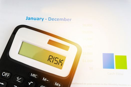 A calculator with the word RISK on the display. Selective focus and crop fragment