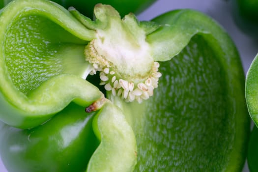 Fresh green bell peppers (capsicum) on a white background. Selective focus and crop fragment