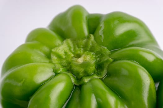 Fresh green bell peppers (capsicum) on a white background. Selective focus and crop fragment