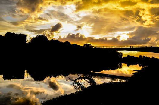 Beautiful yellow Sunset with clouds on the Arno River in Florence, Italy