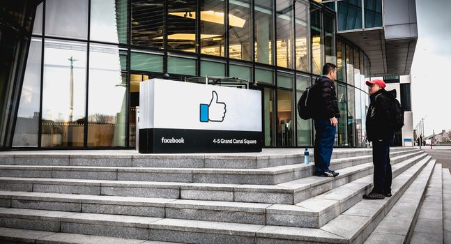 Dublin, Ireland - February 12, 2019: people talking in front of the Irish social seat of the international social network Facebook on a winter day
