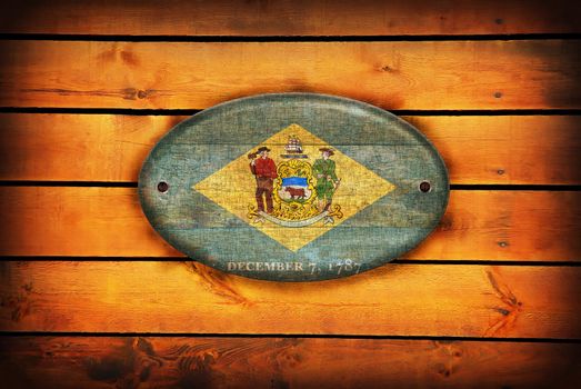 A Delaware flag on brown wooden planks.