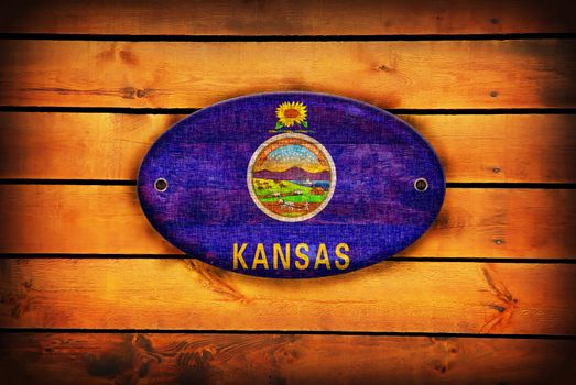 A Kansas flag on brown wooden planks.