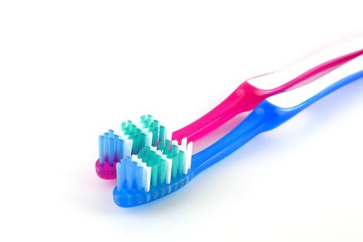 Two tooth-brushes over white