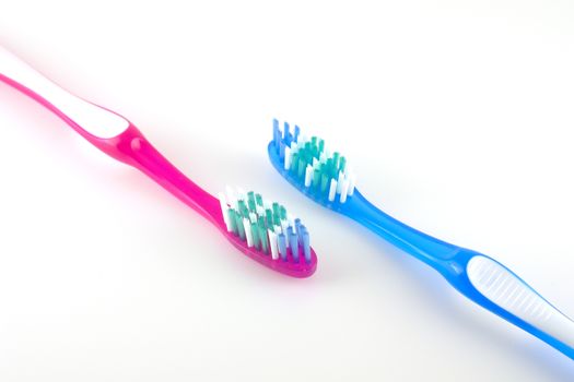 Two tooth-brushes over white