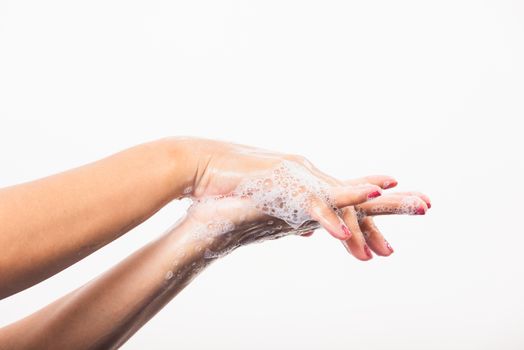 Closeup young Asian woman washing hands by soap for cleanliness and prevent germs coronavirus, studio shot isolated on white background, Healthcare medical COVID-19 virus concept