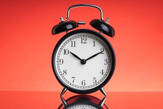 Alarm Clock on red background with selective focus and crop fragment. Business and Copy space concept