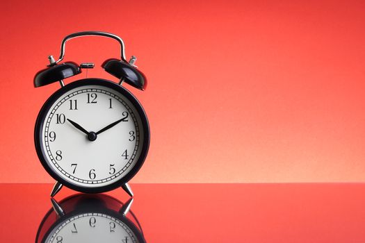 Alarm Clock on red background with selective focus and crop fragment. Business and Copy space concept