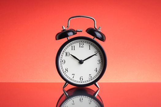 Alarm Clock on red background with selective focus and crop fragment. Business and Copy space concept