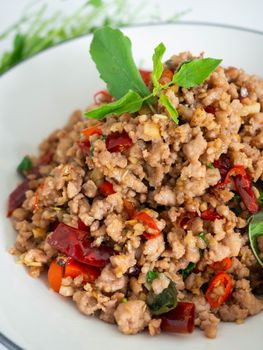 Stir fried basil with minced on a white plate,Thai food hot and spicy flavor. The ingredients are basil, garlic. Minced pork and Chili pepper,White background
