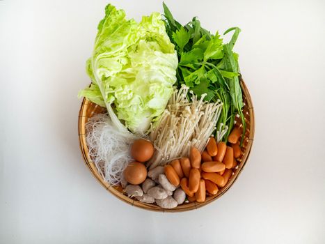 Ingredients Thai Sukiyaki Soup include Mushroom Sausage Pork ball Morning glory Chinese cabbage Vermicelli Celery Egg on basket,White Background