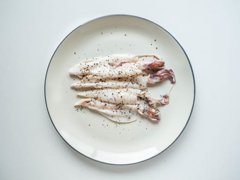 Fresh squid Topping
black pepper from the market on dish White and White background