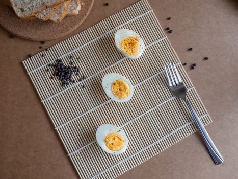 ฺBoiled egg topped with Cayenne pepper Pepper and Salt on a white dish,Egg colors white and yellow,Eat with bread