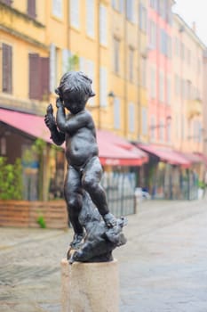 Statue and street scene in the historic center of Modena, Emilia-Romagna, Italy