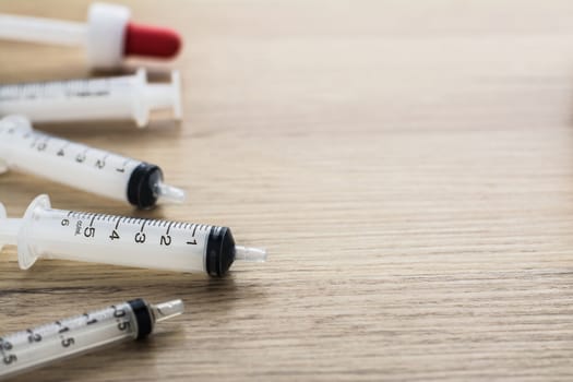 Empty syringes barrel on the wooden table with copy space.