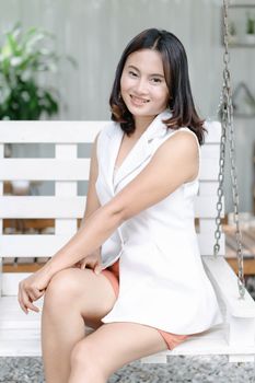 Working woman with smile face sitting on swing in the coffee shop