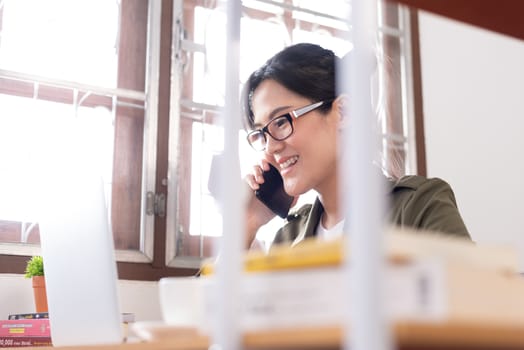 Modern young Asian woman working from home and talking with a partner about her business with happy and smile.