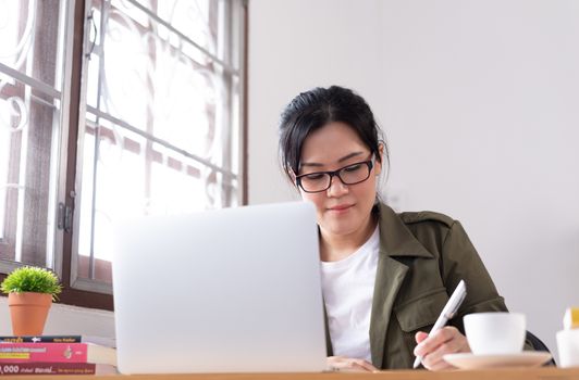 Modern young Asian woman working from home.