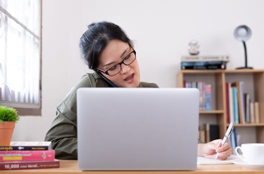 Modern young Asian woman working from home.