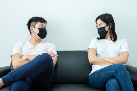An Asian couple wearing a black mask and stays together with boring and social distancing.