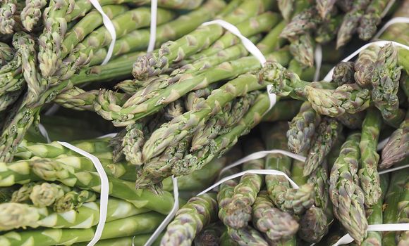 Macro of green asparagus bunches at a food market