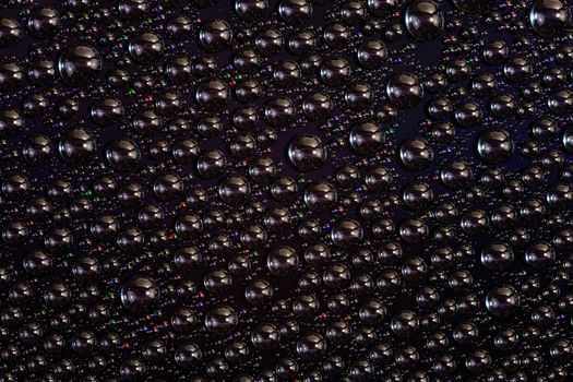 water drops on surface of screen of modern phone, close-up with selective focus and blur.