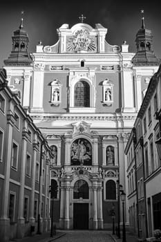 facade of the baroque church decorated with columns and statues in Poznan, black and white