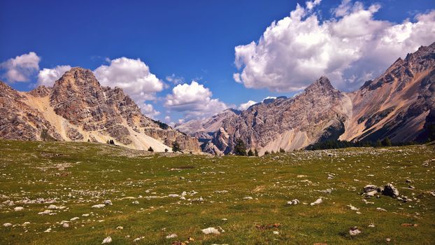 Trentino Alto - Adige, Italy - 06/15/2020: cenic alpine place with magical Dolomites mountains in background, amazing clouds and blue sky in Trentino Alto Adige region, Italy, Europe