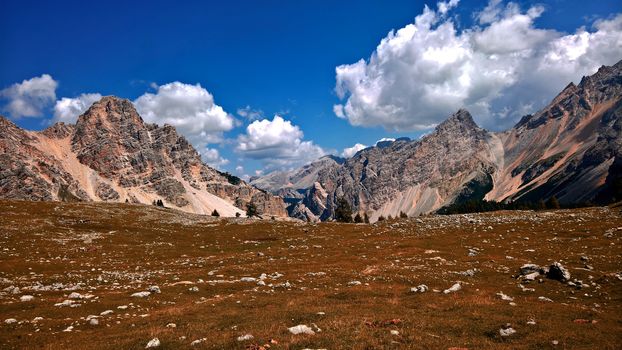 Trentino Alto - Adige, Italy - 06/15/2020: cenic alpine place with magical Dolomites mountains in background, amazing clouds and blue sky in Trentino Alto Adige region, Italy, Europe