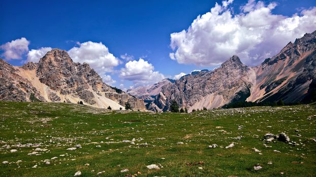 Trentino Alto - Adige, Italy - 06/15/2020: cenic alpine place with magical Dolomites mountains in background, amazing clouds and blue sky in Trentino Alto Adige region, Italy, Europe