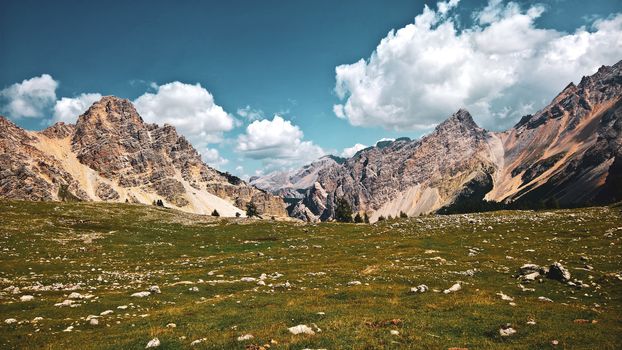 Trentino Alto - Adige, Italy - 06/15/2020: cenic alpine place with magical Dolomites mountains in background, amazing clouds and blue sky in Trentino Alto Adige region, Italy, Europe