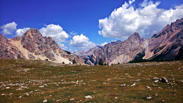 Trentino Alto - Adige, Italy - 06/15/2020: cenic alpine place with magical Dolomites mountains in background, amazing clouds and blue sky in Trentino Alto Adige region, Italy, Europe