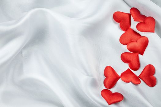 Many red hearts on a wrinkled white background detail object