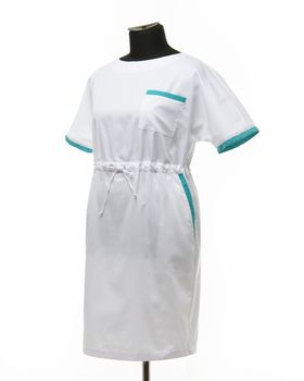 Female medical gown on a mannequin for clothes on a white background