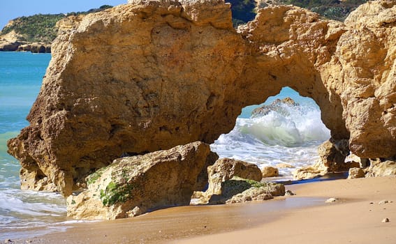 Red cliffs in blue sea at paradise beach Praia da Oura at the Algarve coast of Portugal