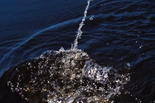 Spray in the water from the paddle. The surface of the water in the river.