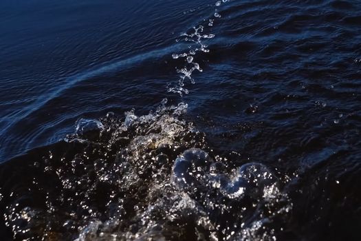 Spray in the water from the paddle. The surface of the water in the river.