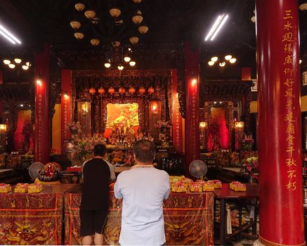 KAOHSIUNG, TAIWAN -- AUGUST 15, 2015: Two men pray at the altar of the Sanfeng Temple, which is one of the oldest temples in Kaohsiung, dating back 300 years.
