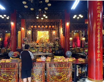 KAOHSIUNG, TAIWAN -- AUGUST 15, 2015: A man prays at the altar of the Sanfeng Temple, which is one of the oldest temples in Kaohsiung, dating back 300 years.
