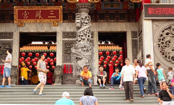 KAOHSIUNG, TAIWAN -- AUGUST 15, 2015: People enter the well-known Sanfeng Temple, which is one of the oldest temples in Kaohsiung, dating back 300 years.

