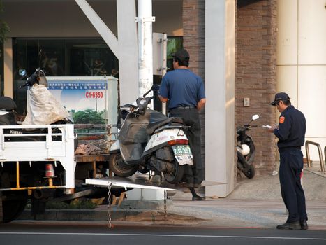 KAOHSIUNG, TAIWAN - DECEMBER 28: Police enforce new traffic rules and tow away illegally parked scooters on December 28, 2011 in Kaohsiung
