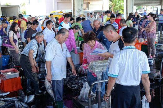 SINDA, TAIWAN -- JUNE 29, 2014: Buyers and sellers are busy at the daily fish auction at Sinda Port in southern Taiwan
